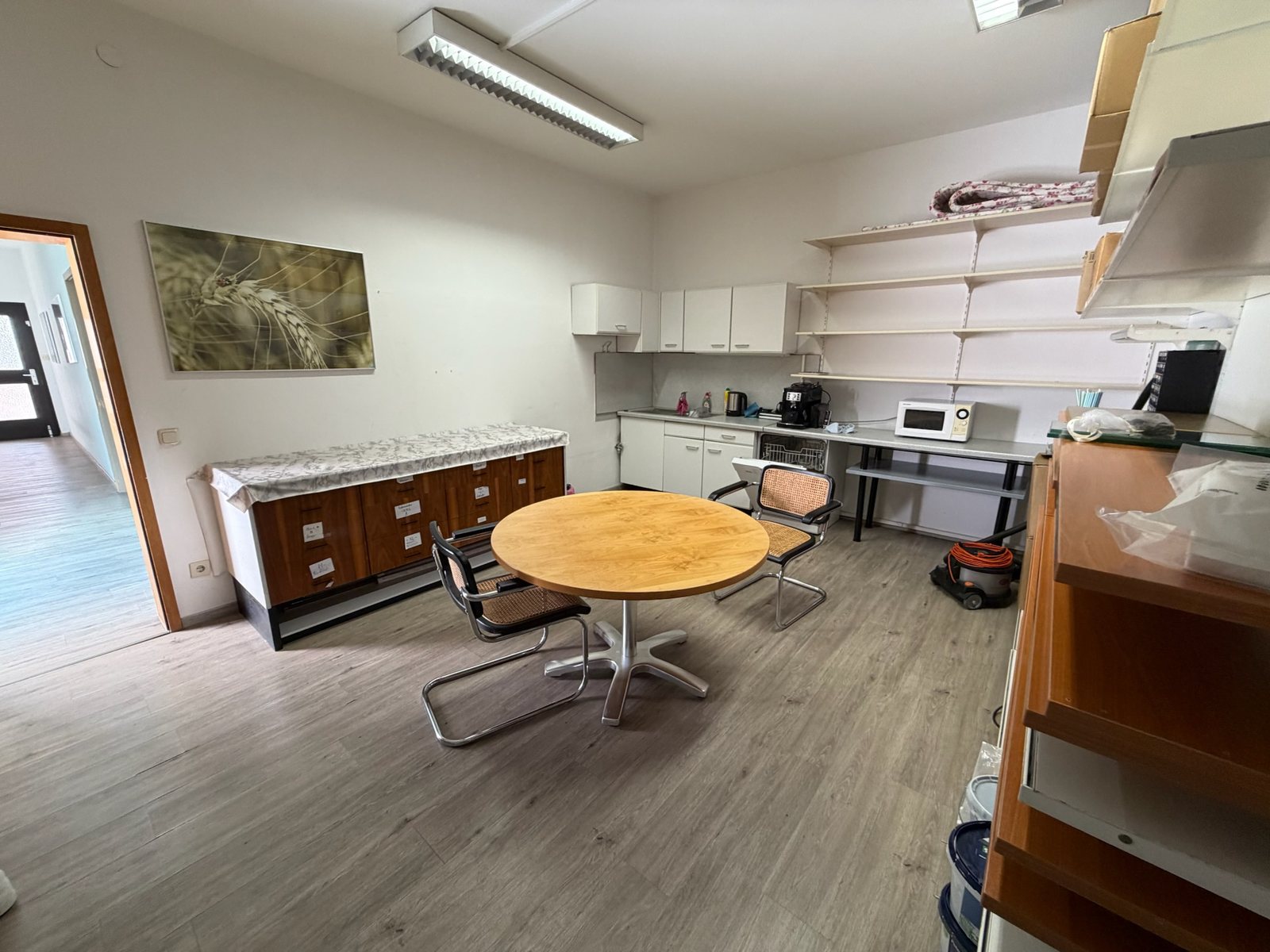Sozialraum mit Küchenzeile, Tisch und Regalwand