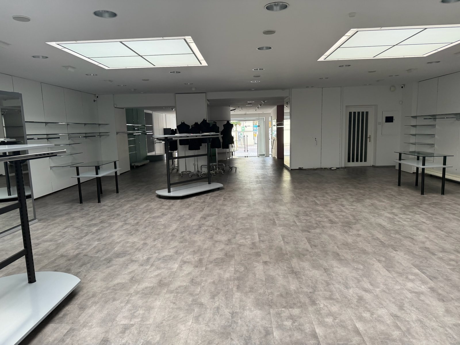 Hinterer Verkaufsbereich, leer, mit vier Oberlichtern und Blick nach vorn zur Straße